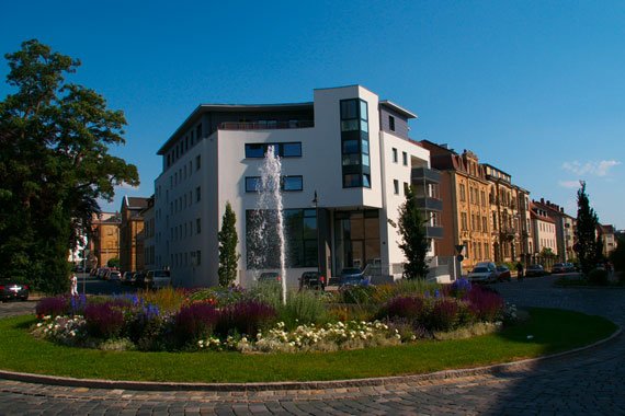 Wilhelmsplatz in Bayreuth mit Springbrunnen, dahinter das Gebaeude mit Architekturbuero