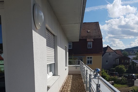 Blick auf ein Haus mit Balkon und Ausblick auf die Nachbarschaft