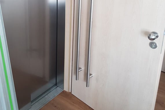 Blick auf eine Tür und den Aufzug einer barrierefreien Wohnung